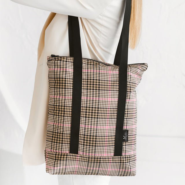 2. Close-up of Muni tartan tote bag with black straps, highlighting stylish pattern and brand tag