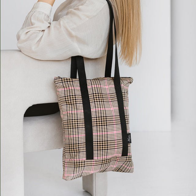 3. Tartan tote bag by Muni, worn by a woman sitting, emphasizing casual elegance and functionality