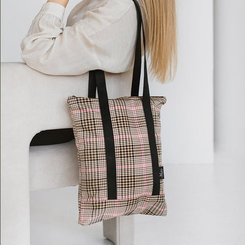 3. Tartan tote bag by Muni, worn by a woman sitting, emphasizing casual elegance and functionality