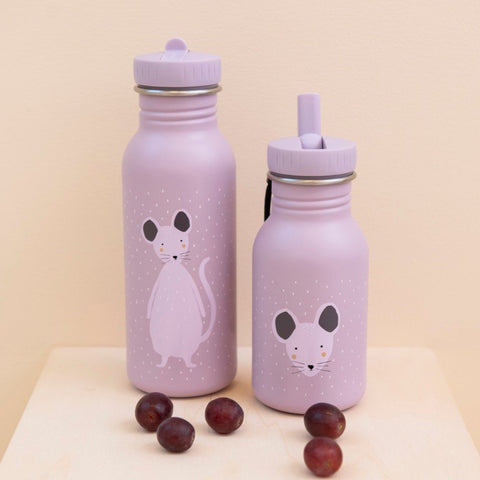 1. Two Trixie Baby Mrs Mouse stainless steel bottles in lavender with mouse illustrations, placed on wooden surface with grapes, showcasing different cap styles