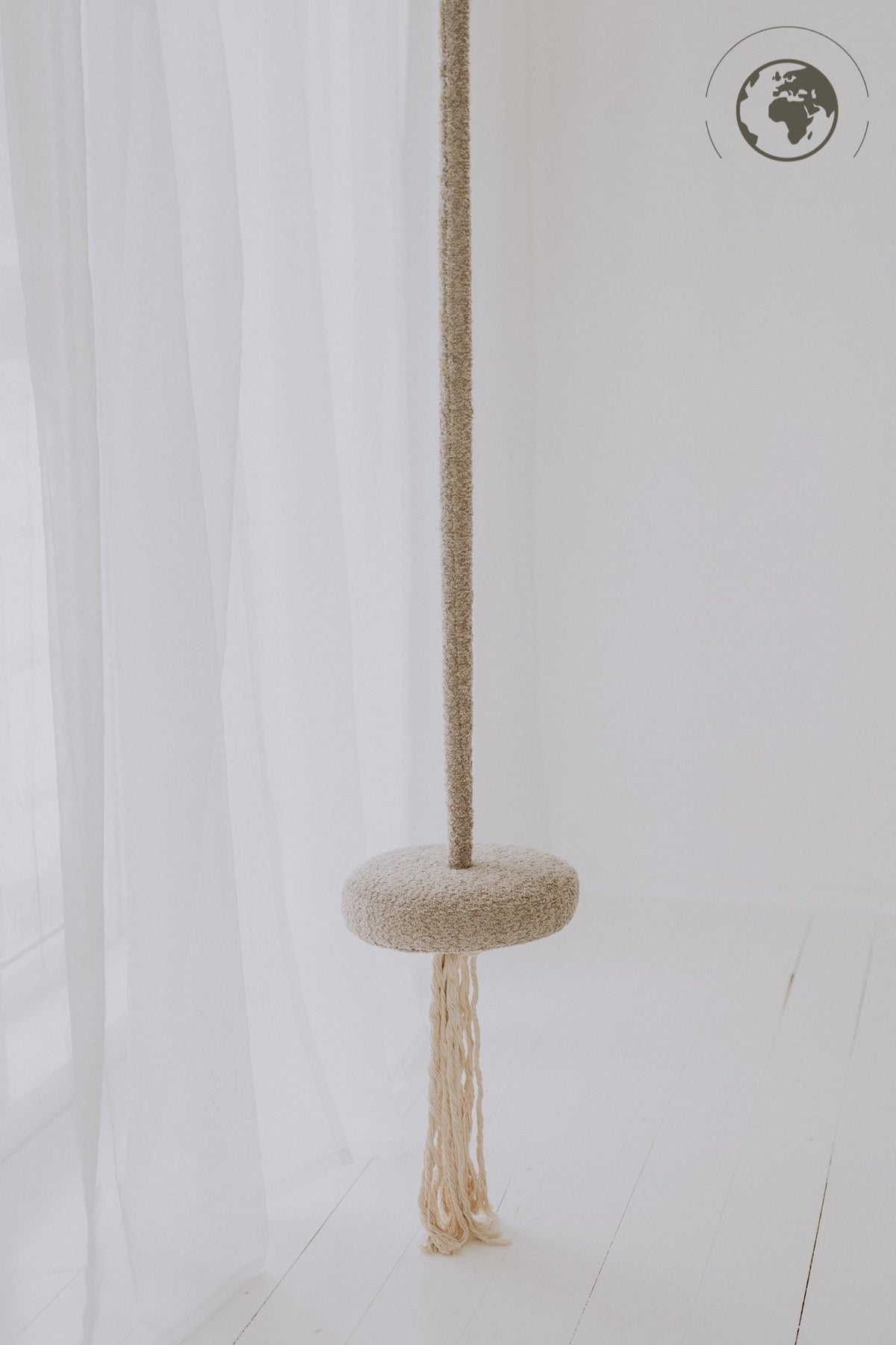 1. Bouclé sand swing with cotton rope hanging in a bright room with sheer curtains