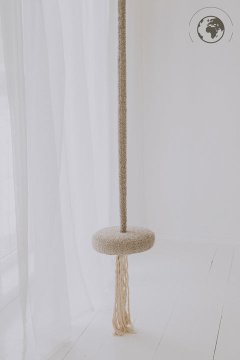 1. Bouclé sand swing with cotton rope hanging in a bright room with sheer curtains