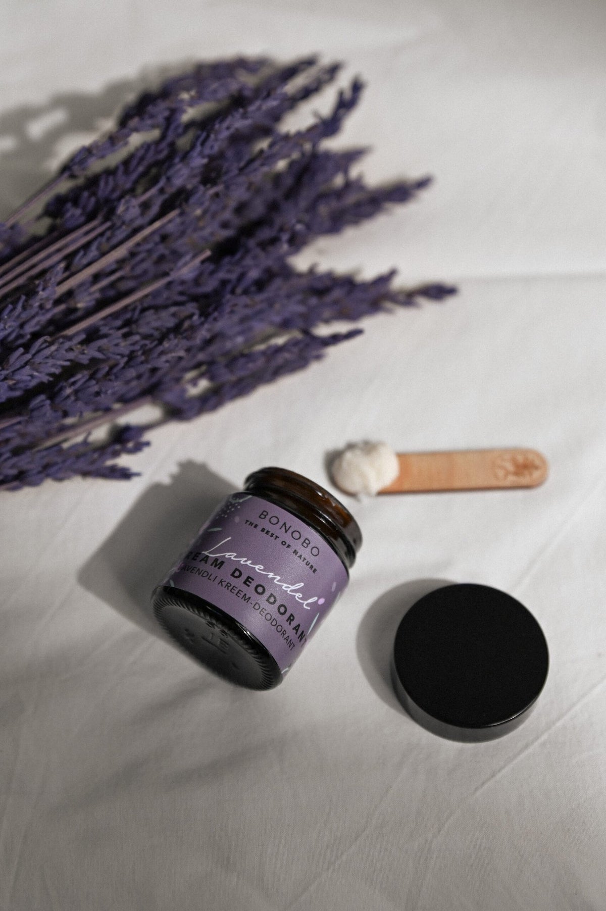 1. BONOBO Lavendel Deodorant-Cream jar with lavender sprigs and wooden spatula on white fabric