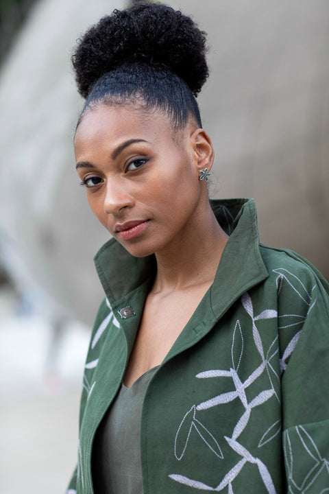 2. Woman wearing Lentsius Lilac Upcycled Earrings with green jacket, highlighting sustainable style