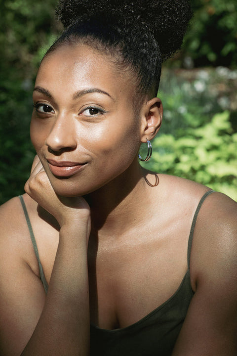 3. Woman posing with Lentsius Linea earrings, emphasizing polished stainless steel craftsmanship in natural light