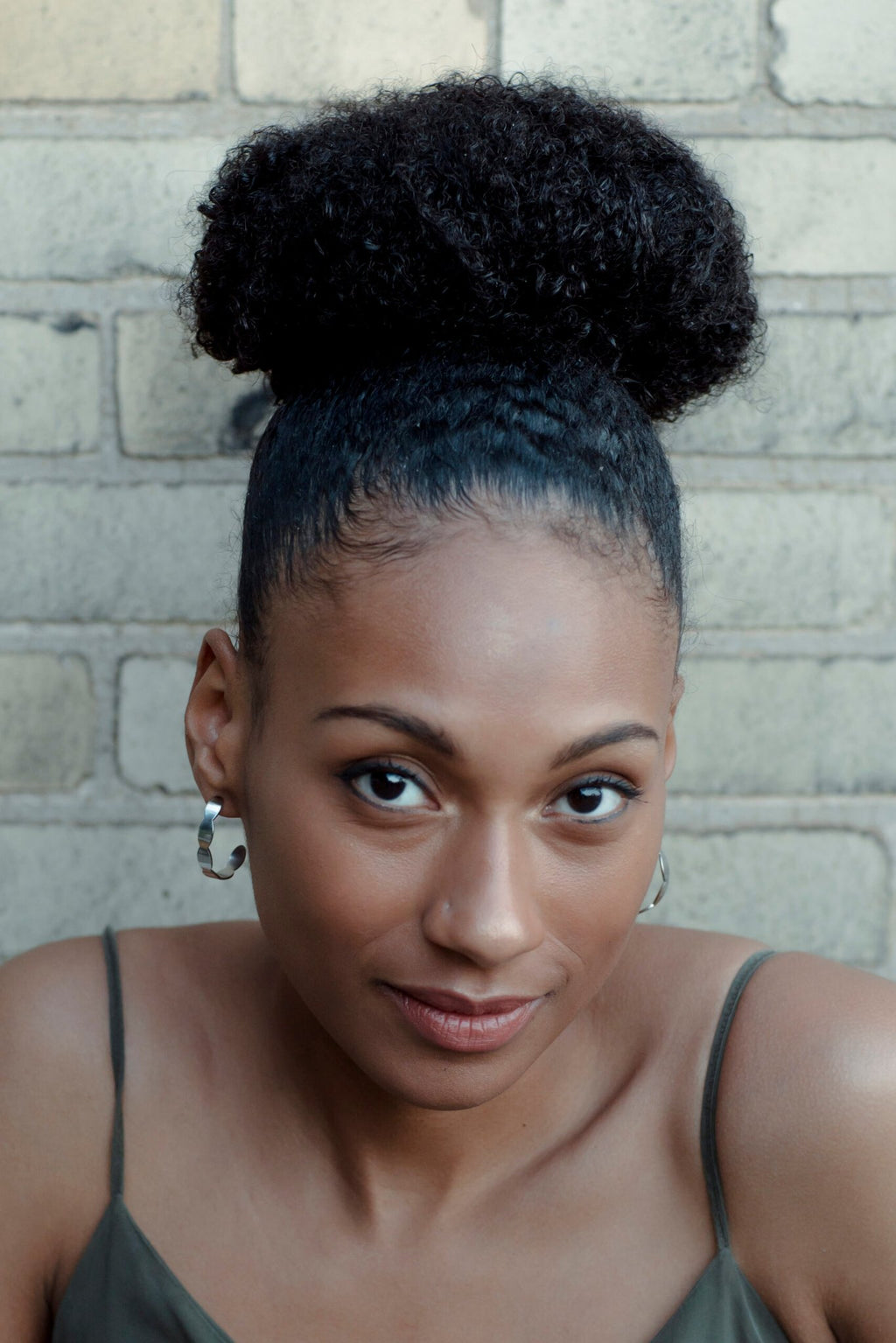 3. Woman smiling while wearing Lentsius Mare stainless steel earrings