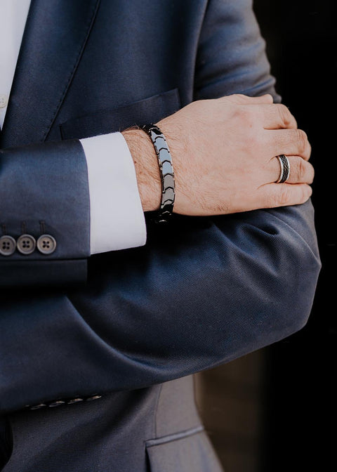1. Man in suit wearing Leomani men's stainless steel ring and bracelet, arms crossed