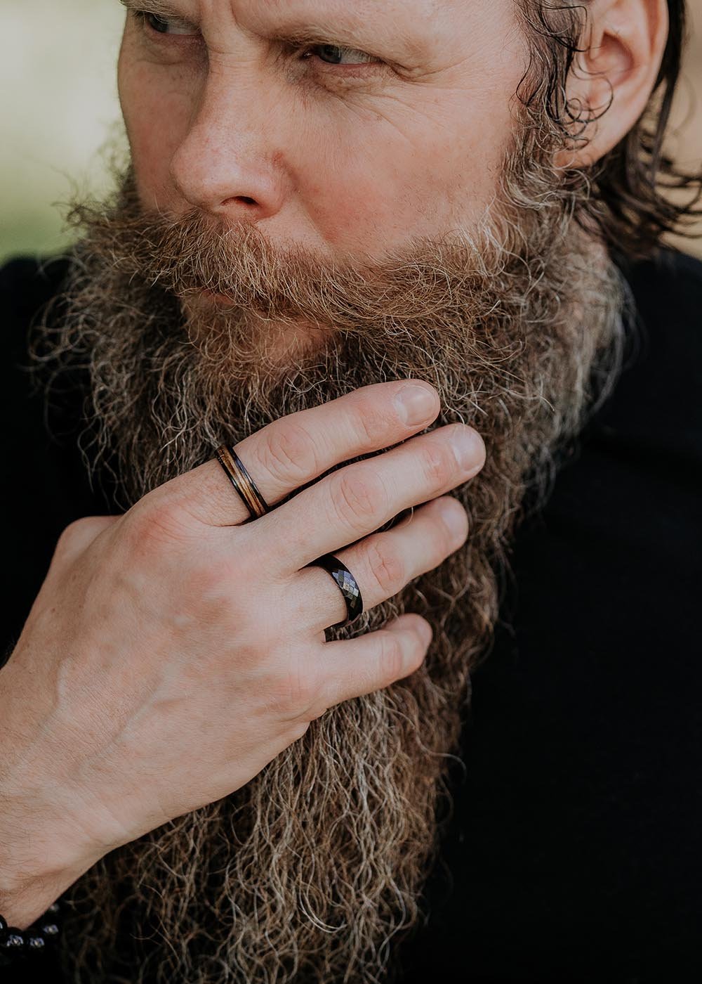 3. Man with beard wearing Leomani men's Kahoy ring in black ceramic and natural veneer, emphasizing contemporary style