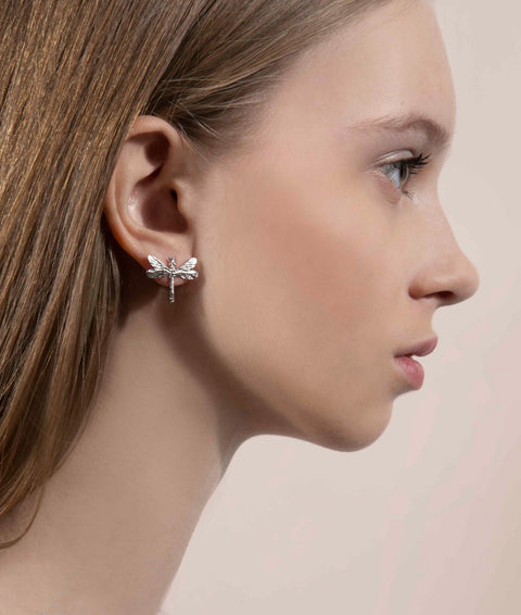1. Woman wearing a silver dragonfly earring, side profile view highlighting the earring's detail