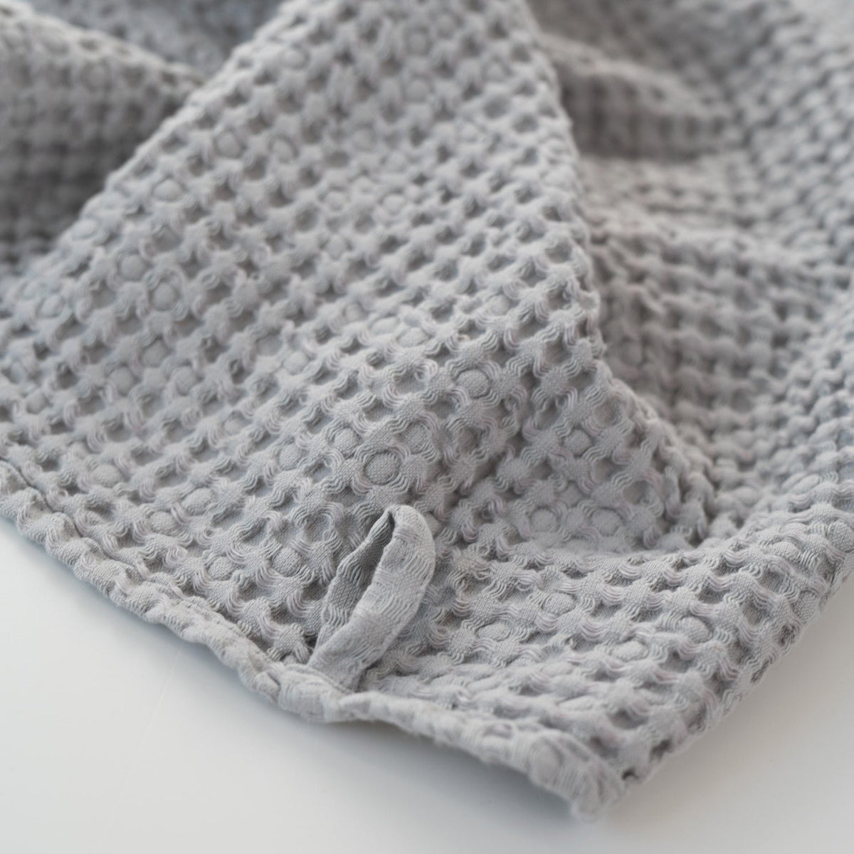 3. Light grey honeycomb waffle towel with hanging loop detail, showing texture and weave
