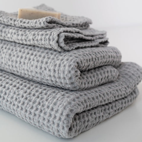 1. Stack of light grey honeycomb waffle towels with a bar of soap on top, showcasing texture and volume