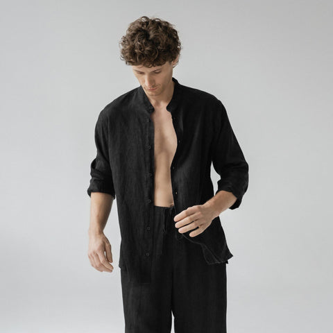 2. Close-up of man in black linen loungewear set with open buttoned top in a studio setting