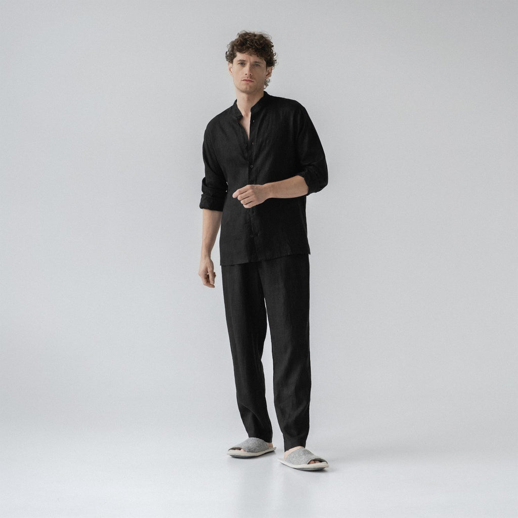 1. Man wearing black linen loungewear set with buttoned top and relaxed trousers in a studio setting