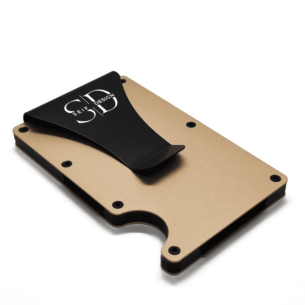 2. Angled view of gold Seif Design card holder with black clip, highlighting minimalist design and aluminum material