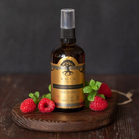 1. HOIA homespa Natural Tanning Oil bottle with raspberries and mint leaves on a wooden surface, highlighting natural ingredients