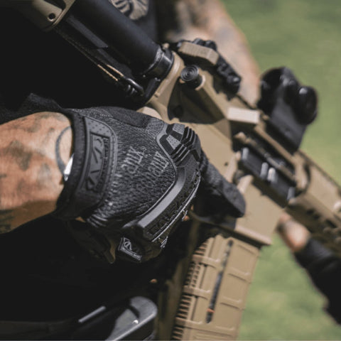 1. Person wearing black Mechanix M-Pact glove holding a rifle outdoors