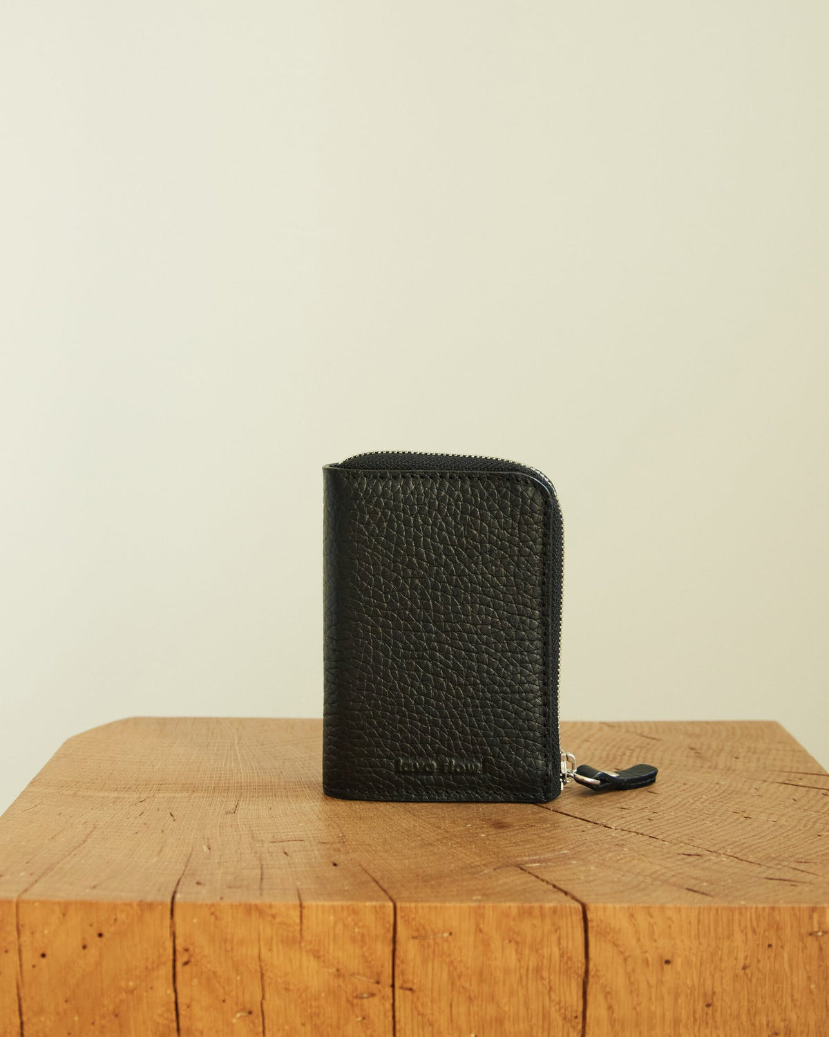 2. Lava Flow Classic Leather Wallet MACA in black, displayed on wooden surface with zippered closure