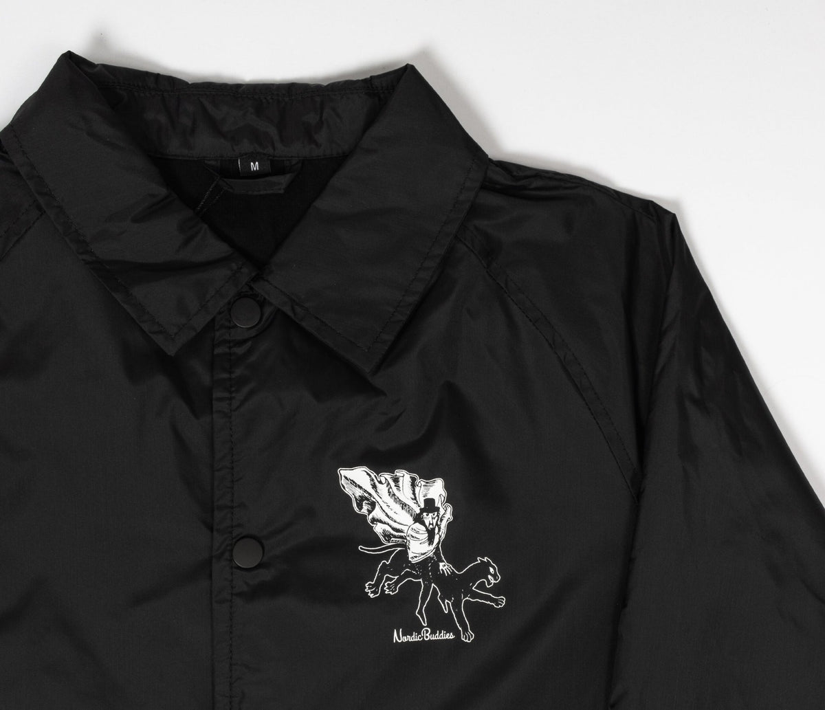 9. Studio shot of unisex black Coach Jacket The Hobgoblin by Moomin highlighting front logo