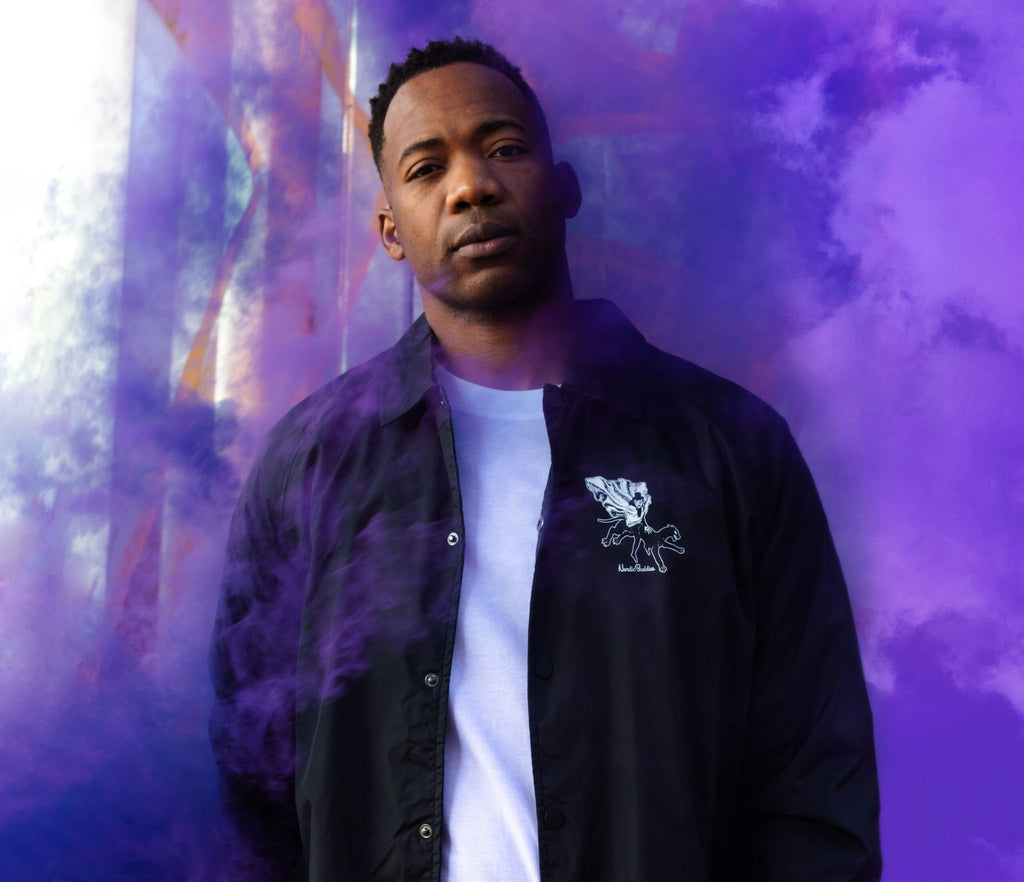 1. Unisex black Coach Jacket The Hobgoblin by Moomin worn by male model in lifestyle setting