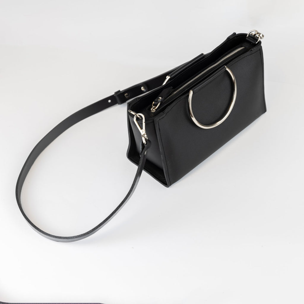 9. PYKOK Handbag Maria Mini in black leather with adjustable strap, shown in studio