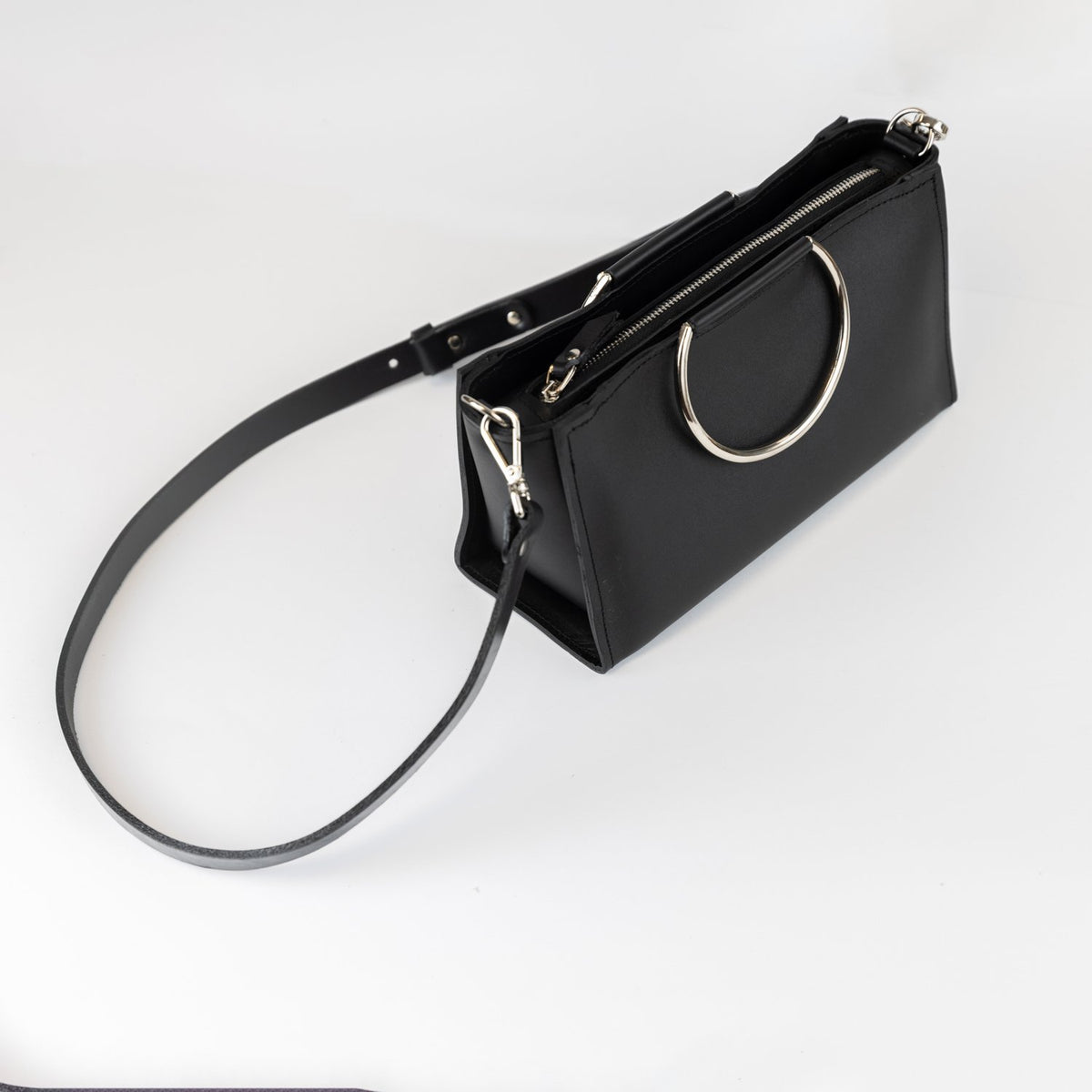 9. PYKOK Handbag Maria Mini in black leather with adjustable strap, shown in studio