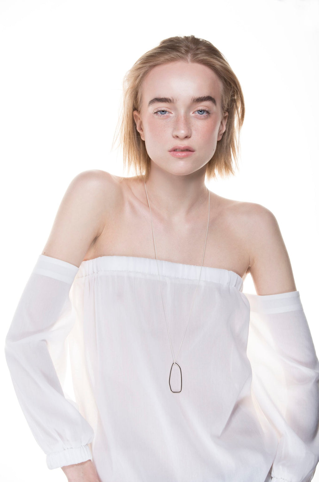 1. Woman wearing Lisa Kroeber Jewellery Frames Silver Necklace in studio setting