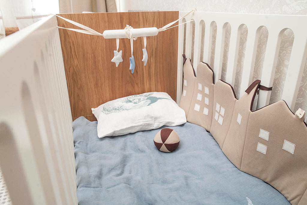 1. Blue star-shaped baby crib toy hanging in a crib, featuring three stars with crinkle and ring sounds, supporting sensory and motor skill development.