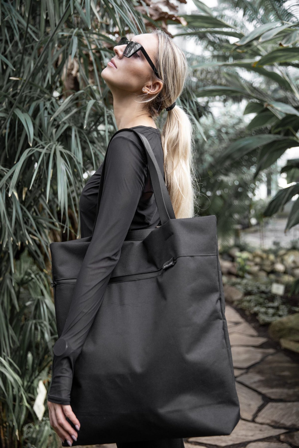 9. Woman wearing sunglasses with Nordhale VIK Tote Bag in black, showcasing its large capacity and chic look