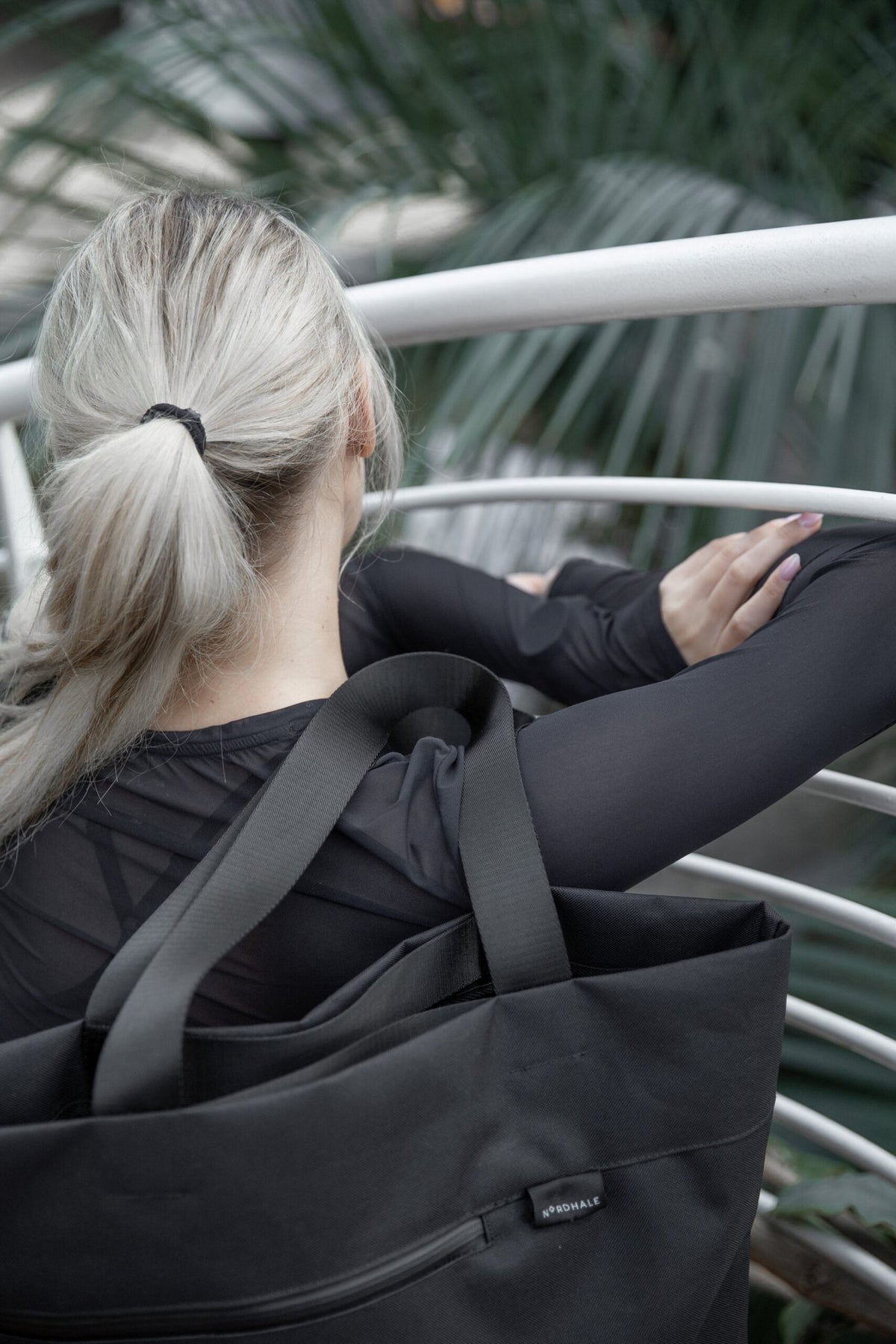11. Woman with Nordhale VIK Tote Bag in black, showing the back view and comfortable strap design