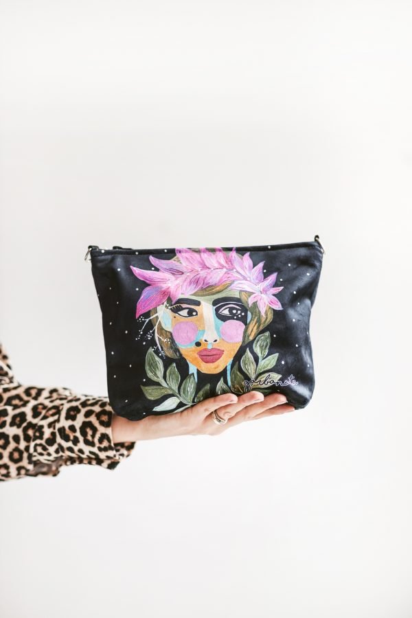 4. Woman holding Garbanota Forest Berry makeup bag with vibrant face design, highlighting portability and style