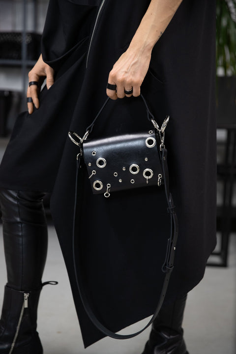 4. Woman in black outfit holding PYKOK Handbag Mia, emphasizing geometric elegance