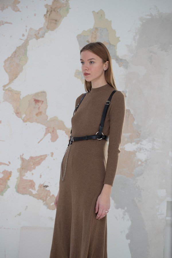 1. Women's Body Harness Milla by PYKOK worn over a brown dress, showcasing versatile leather design with metal chain accents in a lifestyle setting