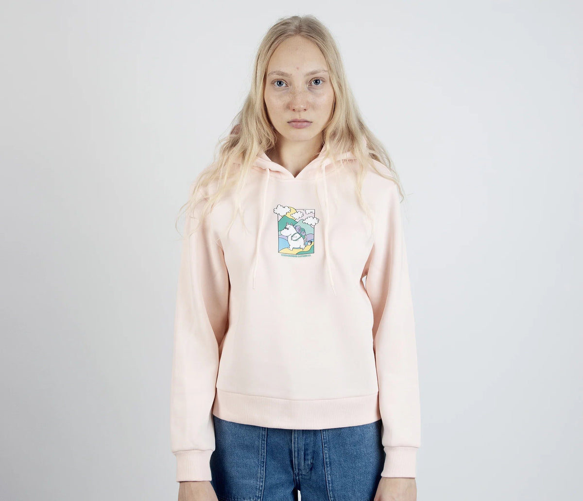 1. Women's light pink Moomintroll's Adventure Hoodie by NordicBuddies, featuring Moomin graphic, worn by female model in studio