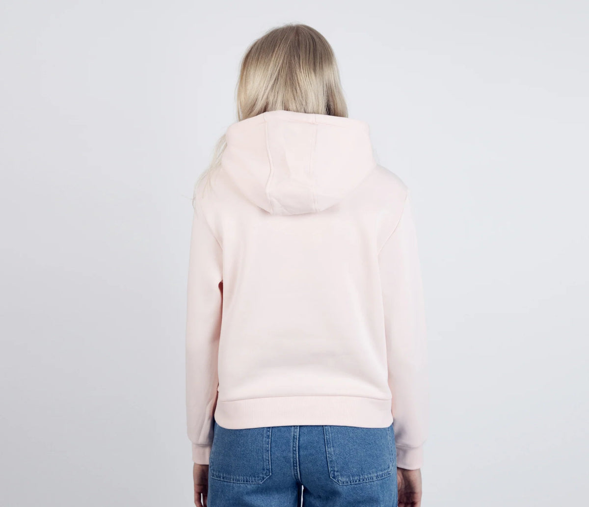 2. Back view of women's light pink Moomintroll's Adventure Hoodie by NordicBuddies, worn by female model in studio