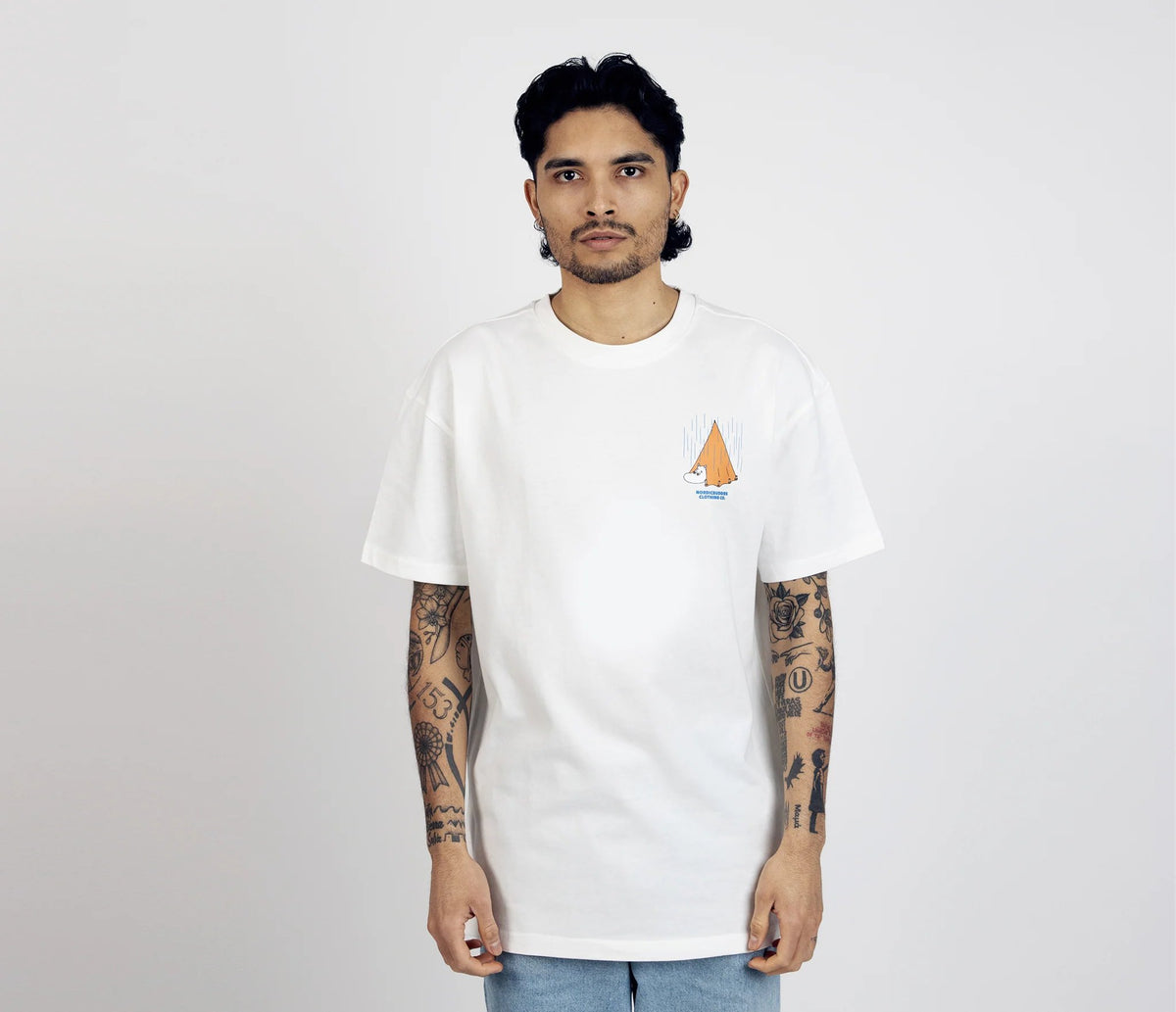 7. Unisex white Moomin Adventure T-Shirt worn by male model, front view with small tent graphic on chest