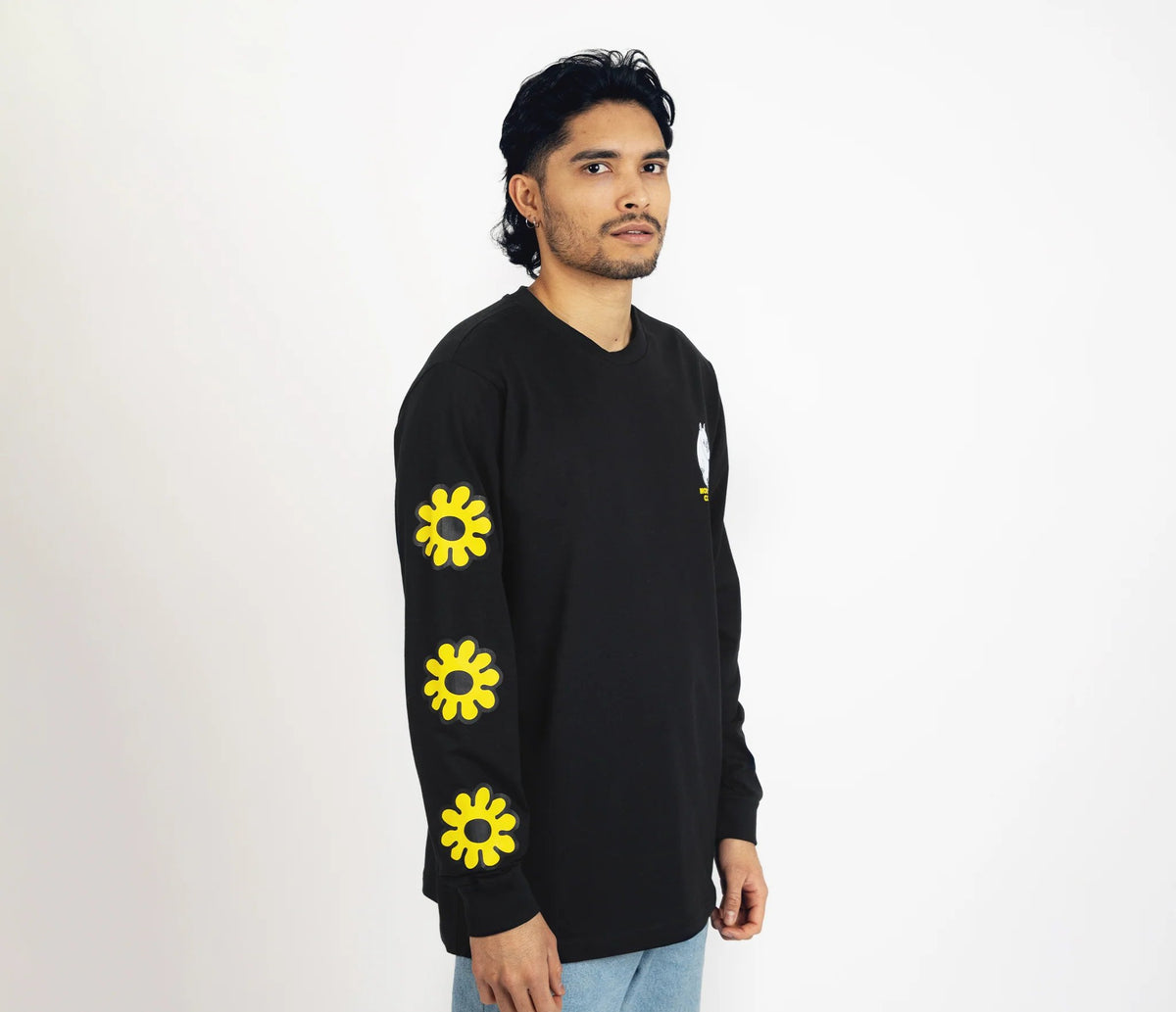 6. Unisex black Moomintroll's Flower longsleeve shirt worn by male model, side view with yellow floral sleeve design