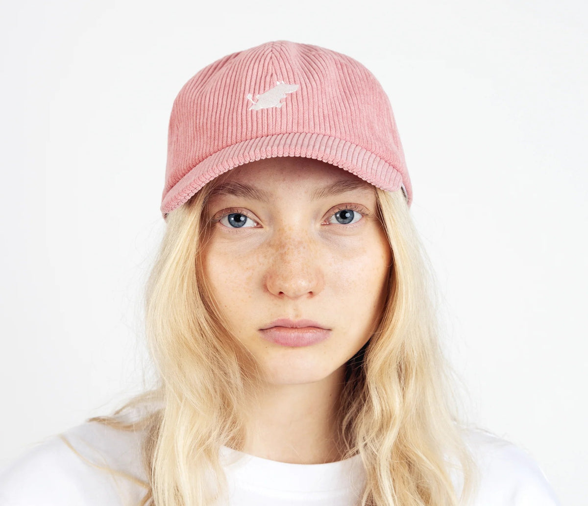 3. Unisex pink Moomintroll corduroy cap worn by female model in studio, front view