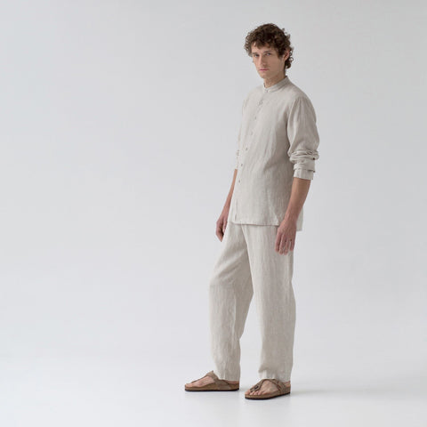 1. Man wearing beige linen loungewear set with long sleeves and buttoned front, standing in studio setting