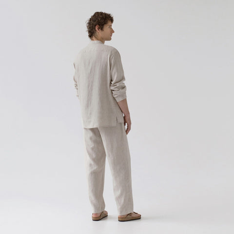 2. Man wearing beige linen loungewear set shown from back, standing in studio