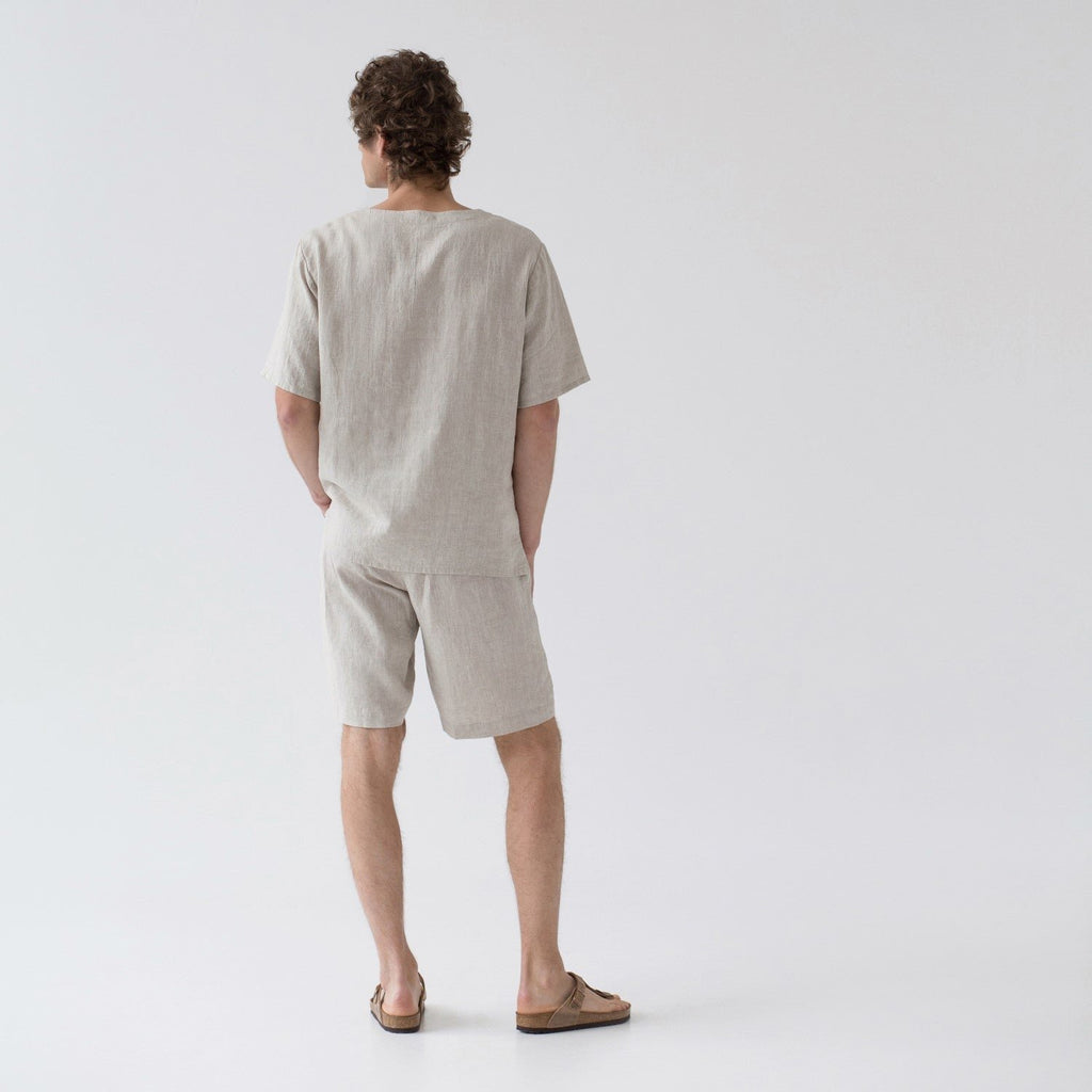 2. Back view of men's beige linen pyjama set with short sleeves and shorts, shown in studio setting