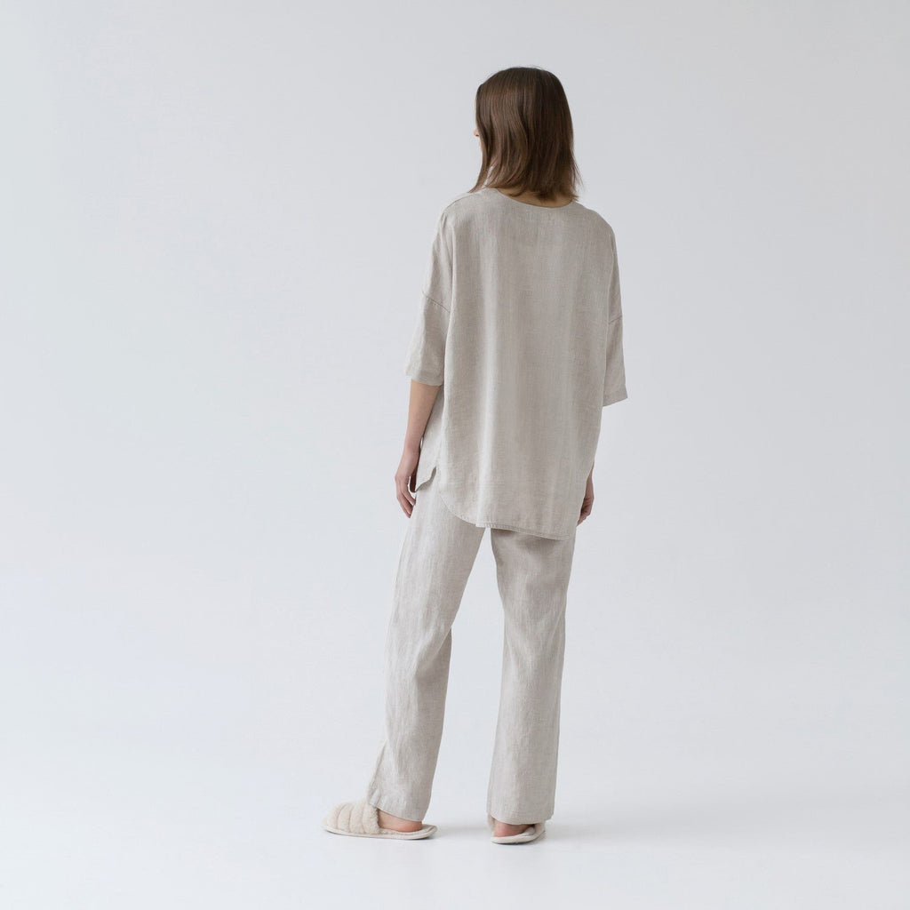 1. Woman wearing melange linen loungewear set shown from back in studio setting