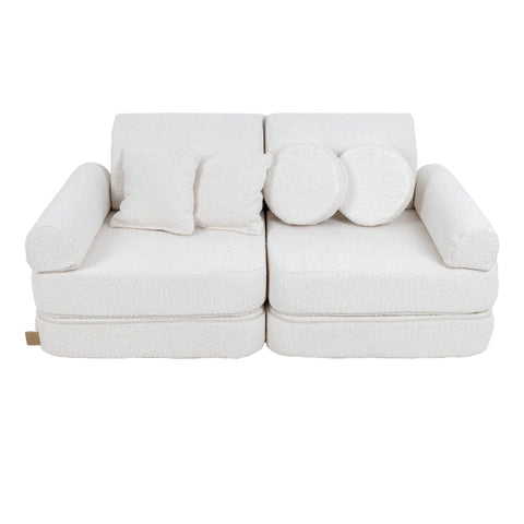 1. Medium modular children's sofa in white boucle fabric with two round and two square cushions, shown in a studio setting