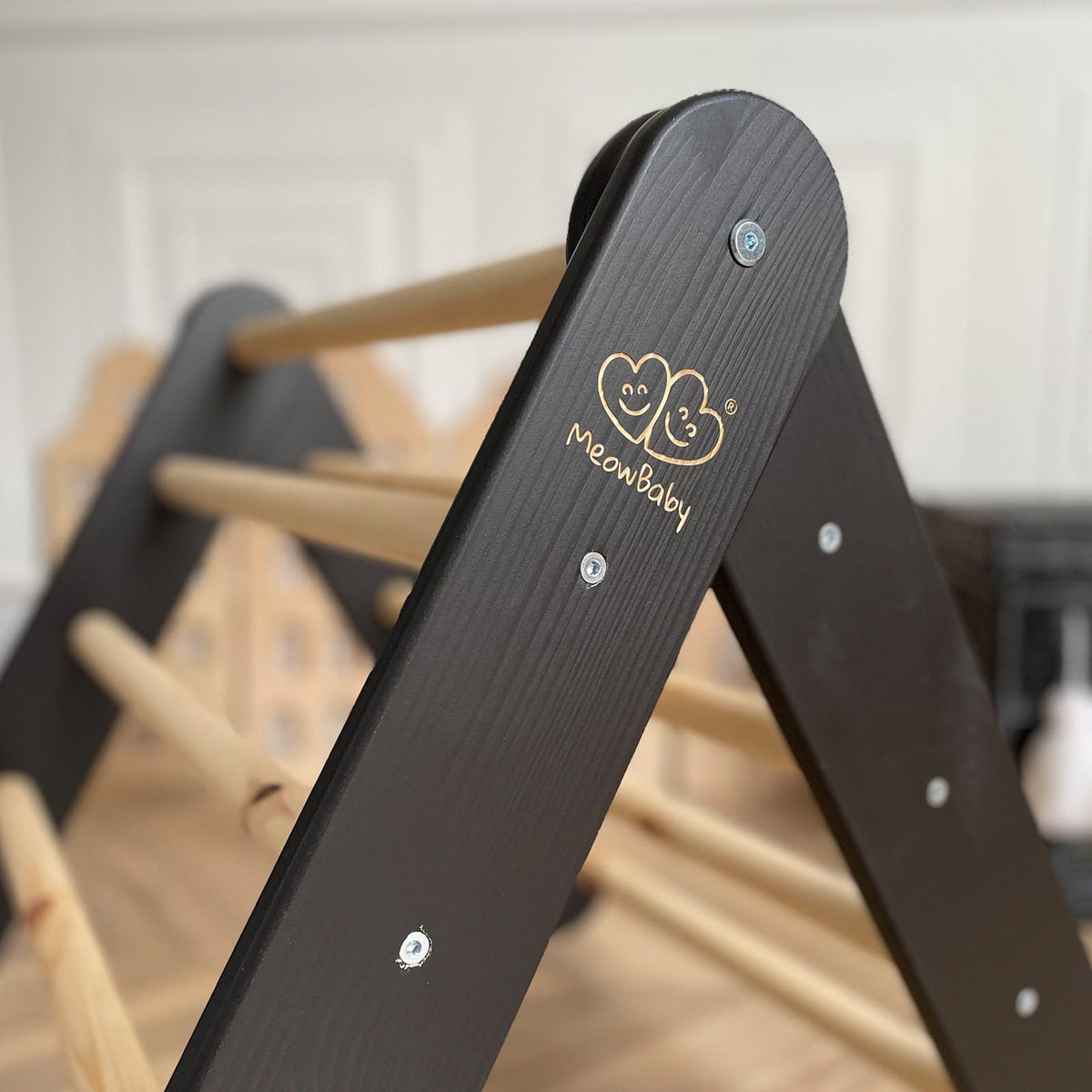 3. Close-up of black side of wooden Pikler climbing ladder with MeowBaby logo, room setting