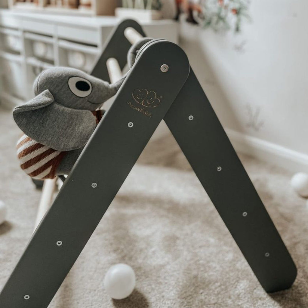 1. Grey wooden ladder structure in children's room with plush toy, showcasing play setting