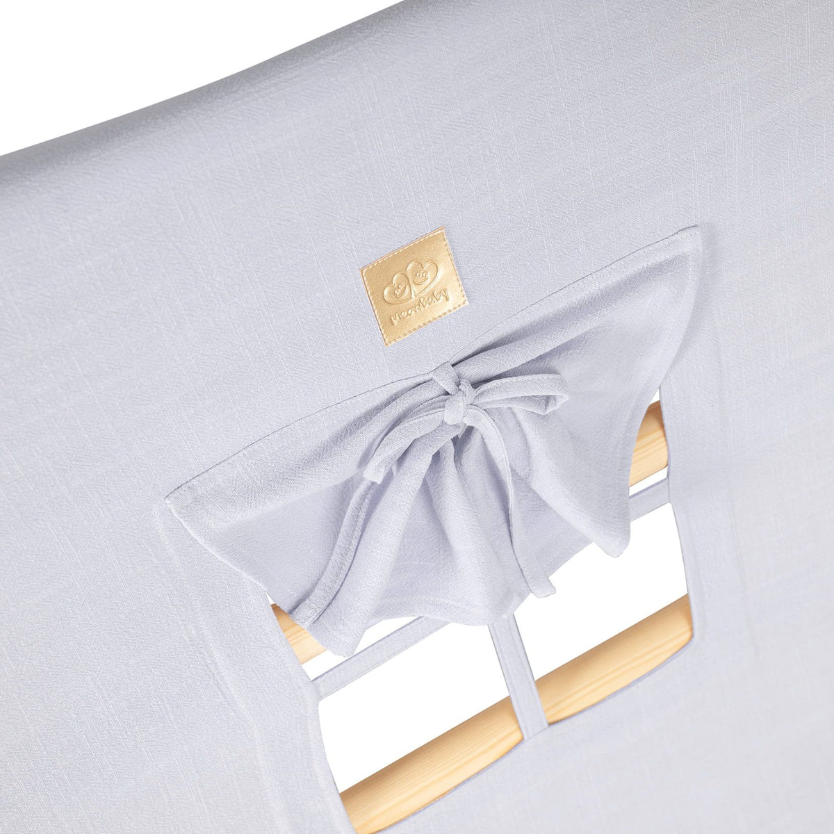 9. Close-up of light grey cover with window and bow detail on ladder house