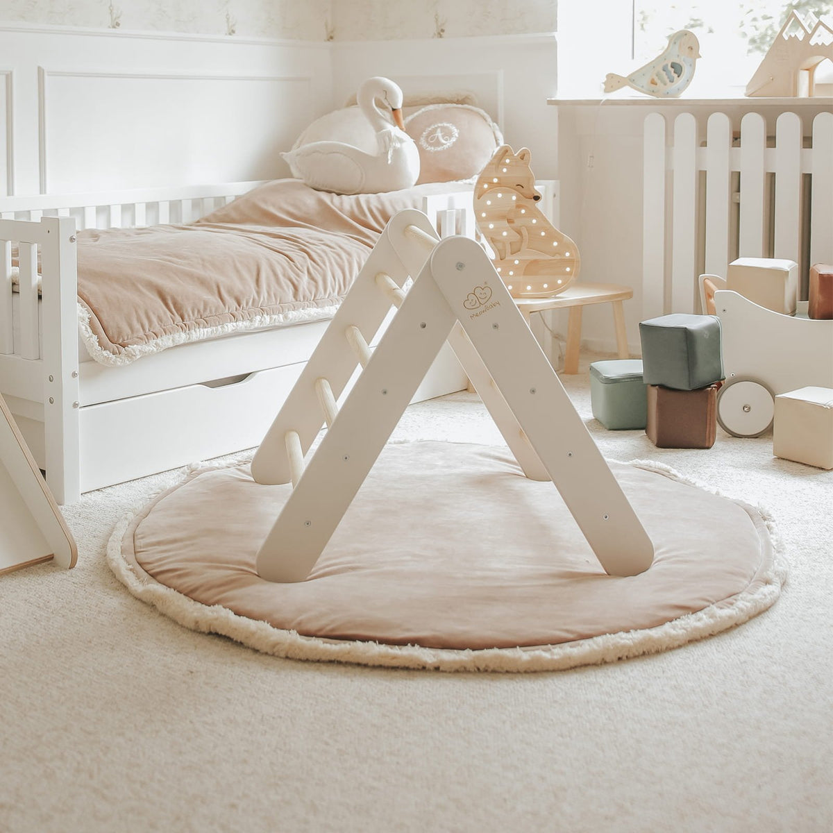 2. White wooden Pikler ladder in a cozy children's room with plush toys and soft lighting