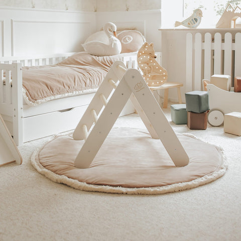 2. White wooden Pikler ladder in a cozy children's room with plush toys and soft lighting