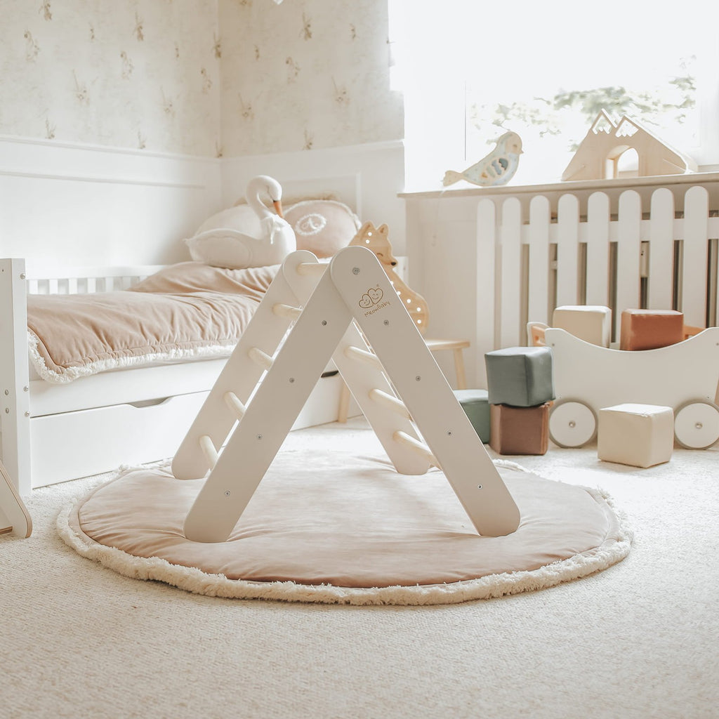 6. White wooden Pikler climbing ladder on a round mat in a softly lit children's room