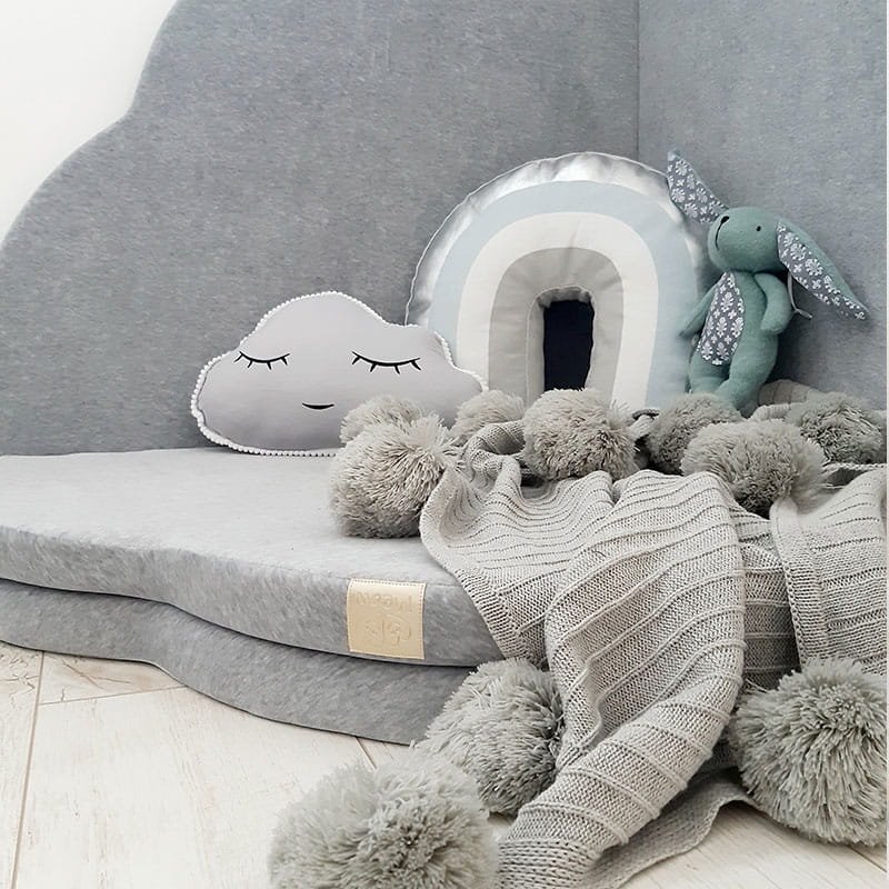 2. Close-up of light grey cloud-shaped play mat with decorative pillows and plush toy