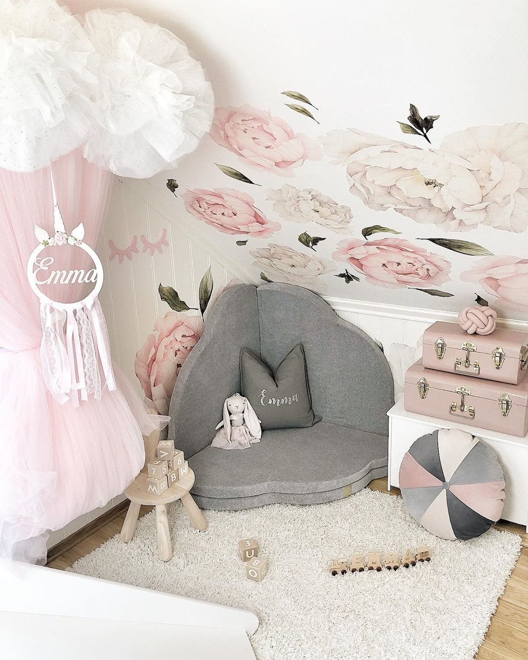 8. Light grey cloud-shaped play mat in floral-themed playroom with decorative items